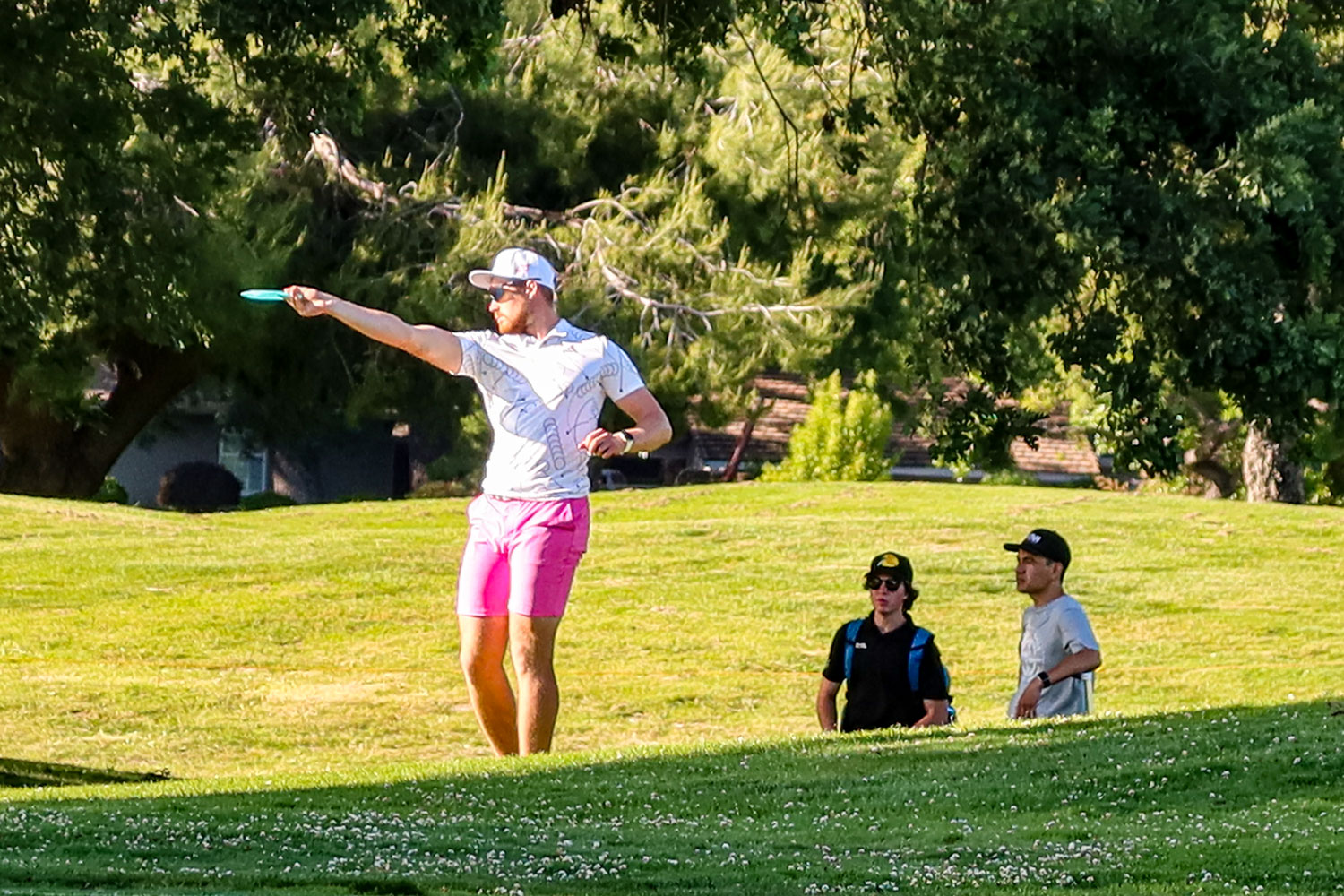 A professional disc golfer throwing a forehand